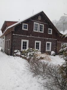 una casa cubierta de nieve delante en Pension Slunečnice, en Pec pod Sněžkou