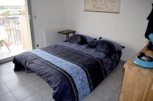 Schlafzimmer mit einem Bett mit blauer Decke in der Unterkunft F2 saint Cyprien Plage in Saint-Cyprien