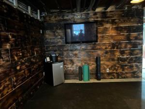 Cette chambre est dotée d'un mur avec une télévision sur un mur en bois. dans l'établissement Breathtaking Rustic Farmhouse Getaway, à Seward