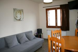uma sala de estar com um sofá e uma mesa de jantar em Cal Xesc em Castellar de NʼHug