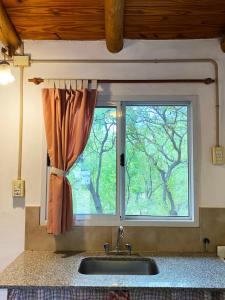 um lavatório numa cozinha com uma janela em Casita Libertad en San Marcos em San Marcos Sierras