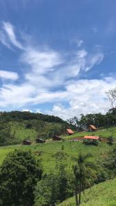 un campo verde con case in cima a una collina di Morada da Serrinha a Santo Antônio do Pinhal