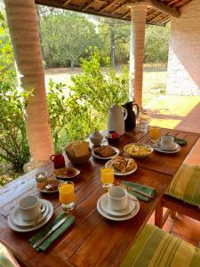 una mesa de madera con comida y bebidas. en Posada Morotí en Esquina