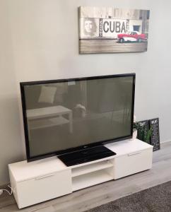 a large flat screen tv sitting on a white entertainment center at Kodikas kaksio keskustassa in Pori
