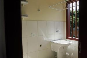 a bathroom with a white toilet and a sink at Vila do Frei in Paraty
