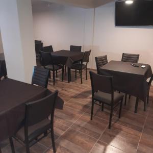 une salle à manger avec des tables et des chaises noires dans l'établissement Hospedaje Champaqui, à Santa Rosa de Calamuchita