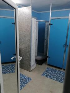 a bathroom with two doors and blue walls and tile floors at River Hostel Belgrade in Belgrade