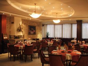 a dining room with tables and chairs in a restaurant at The Regent Club Hotel in Niš