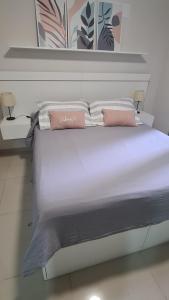 a large bed with two pink pillows on it at II Opera Towers Villa Carlos Paz in Villa Carlos Paz