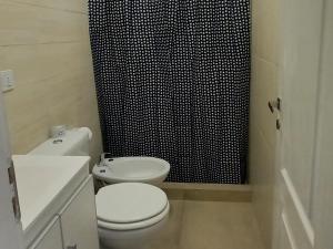 uma casa de banho com um WC e uma cortina de chuveiro em preto e branco em -BLA BLA... em Ushuaia