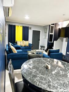 a living room with a table and a blue couch at Luxury Crib 5 mins from the NMIA airport in Kingston