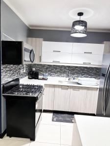 a kitchen with a black stove and a sink at Luxury Crib 5 mins from the NMIA airport in Kingston