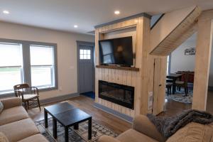ein Wohnzimmer mit einem Kamin und einem TV in der Unterkunft Captain Dan's Shanty in Saint Andrews
