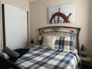 a bedroom with a bed with a blue and white checked blanket at La Cabane chez Jimmy in Petit-Saguenay