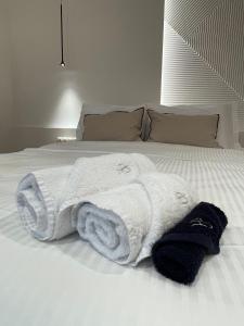 biały ręcznik leży na łóżku w obiekcie Petrou Suites w mieście Janina
