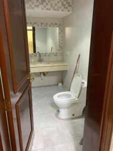 ein Badezimmer mit einem WC, einem Waschbecken und einem Spiegel in der Unterkunft درة العروس شاليه لونج بيتش in Durrat Al-Arus