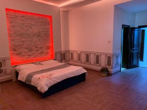 ein Schlafzimmer mit einem Bett mit einem roten Gemälde an der Wand in der Unterkunft درة العروس شاليه لونج بيتش in Durrat Al-Arus