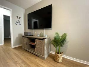 a living room with a flat screen tv on a wall at White Sand Getaway steps from Beach in Gulfport