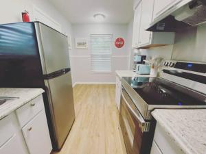 a kitchen with a refrigerator and a stove top oven at White Sand Getaway steps from Beach in Gulfport