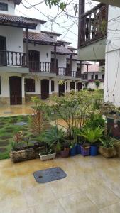 a courtyard with potted plants in front of a building at Casa temporada Peró Cabo Frio in Cabo Frio