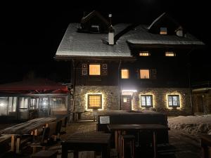 a building at night with tables in front of it at Zoncolan Laugiane in Sùtrio