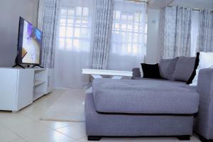 un soggiorno con divano e TV a schermo piatto di Lovely 3 bedroom apartment, kisii a Kisii