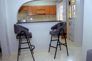 a kitchen with two bar stools in front of a counter at Lovely 3 bedroom apartment, kisii in Kisii