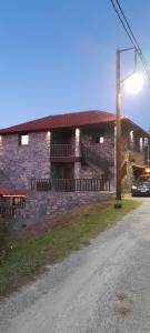 a large stone building with a road in front of it at Guesthouse Sofia in Palaios Agios Athanasios