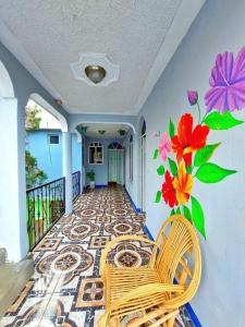 un pasillo con 2 sillas y flores en la pared en Alojamiento San Juan, en San Juan La Laguna