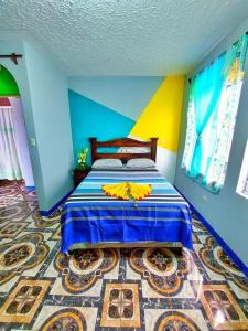 a bedroom with a bed with blue and yellow walls at Alojamiento San Juan in San Juan La Laguna