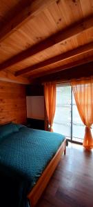 Schlafzimmer mit einem Bett mit Holzdecke in der Unterkunft Cabaña en Los Romeros Con Con in Concón