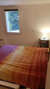 a bedroom with a large bed with a window at Location Rez de maison dans quartier charmant in Saint-Raphaël