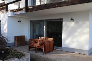 a wooden table and chairs sitting outside of a house at Ferien in Finning - im traumhaften Fünfseenland in Finning