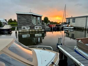 阿斯米尔Quiet Waterloft near Amsterdam and Schiphol WS17的船停靠在码头上,有房子