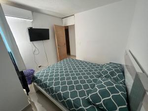 a bedroom with a bed and a television on the wall at Apto nuevo, amoblado sector tranquilo, buen precio in Barranquilla