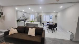 JstLikeHome - Serenity Suites في أوتاوا: غرفة معيشة ومطبخ مع أريكة وطاولة