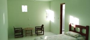 - une chambre avec un lit, une table et des chaises dans l'établissement Pousada Rio Nilo, à Nilo Peçanha