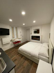 ein weißes Schlafzimmer mit einem Bett und einem Waschbecken in der Unterkunft Luxury 1 al Duomo di Parma in Parma
