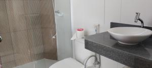 a bathroom with a sink and a shower and a toilet at Pousada Rio Nilo in Nilo Peçanha