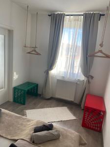 una sala de estar con una gran ventana con cortinas en Gyöngy Apartman en Sopron