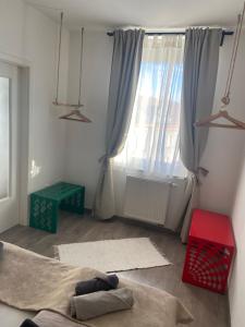 una sala de estar con una gran ventana con cortinas en Gyöngy Apartman, en Sopron