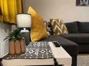 uma sala de estar com um sofá e uma mesa com um candeeiro em Modern and Stylish 1bed flat em Barking