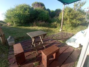 a picnic table and a bench on a brick ground at Polonesa in Cabo Polonio