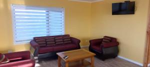 a living room with a couch and a chair at Cabañas Quimantu-Aguas Calientes in Puerto Varas