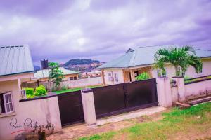 une maison avec une clôture devant elle dans l'établissement Dayspring Apartments. Entire house for guests. Ekiti, à Ado Ekiti