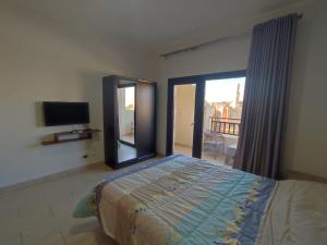 a bedroom with a bed and a sliding glass door at Lovely studio Al-Dau Heights in Hurghada