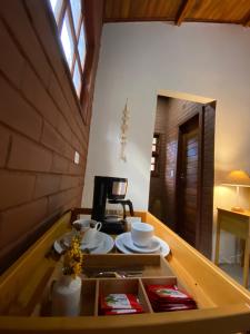 una habitación con una mesa con platos. en Chalés Vila Do Vale en Vale do Capao