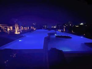 ein großer Pool in der Nacht mit blauen Lichtern in der Unterkunft Lovely studio Al-Dau Heights in Hurghada