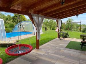a patio with a tent and a hammock on the grass at Kútvölgy Vendégház in Vác
