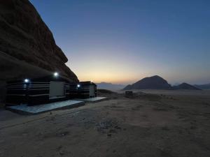 a building in the middle of the desert at night at Bright stars rum camp in Wadi Rum